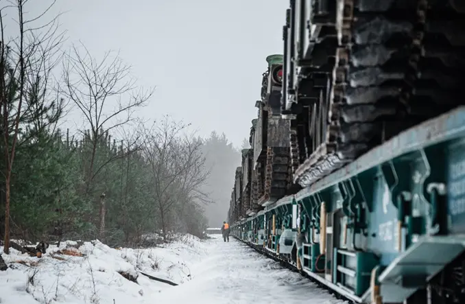 Transport wojskowy przewożony koleją w zimowym krajobrazie